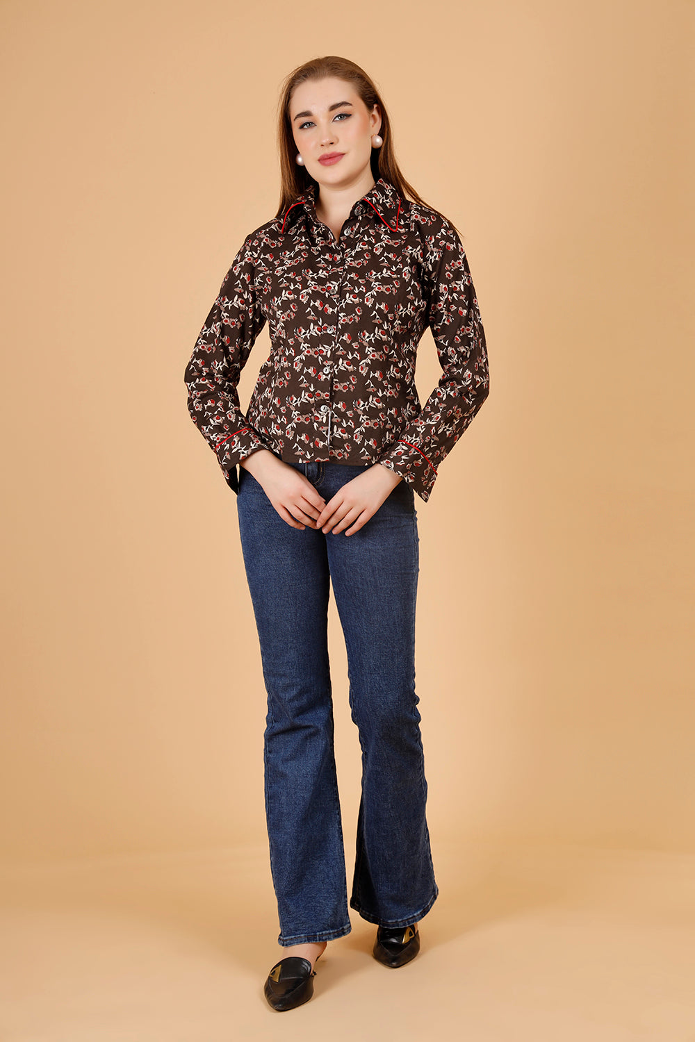 The model wears a comfortable womens blouse- a blockprinted cotton shirt, in colour brown, with red and beige jaipuri print, a structures short shirt for women, which is perfect for casual wear as well as office shirt