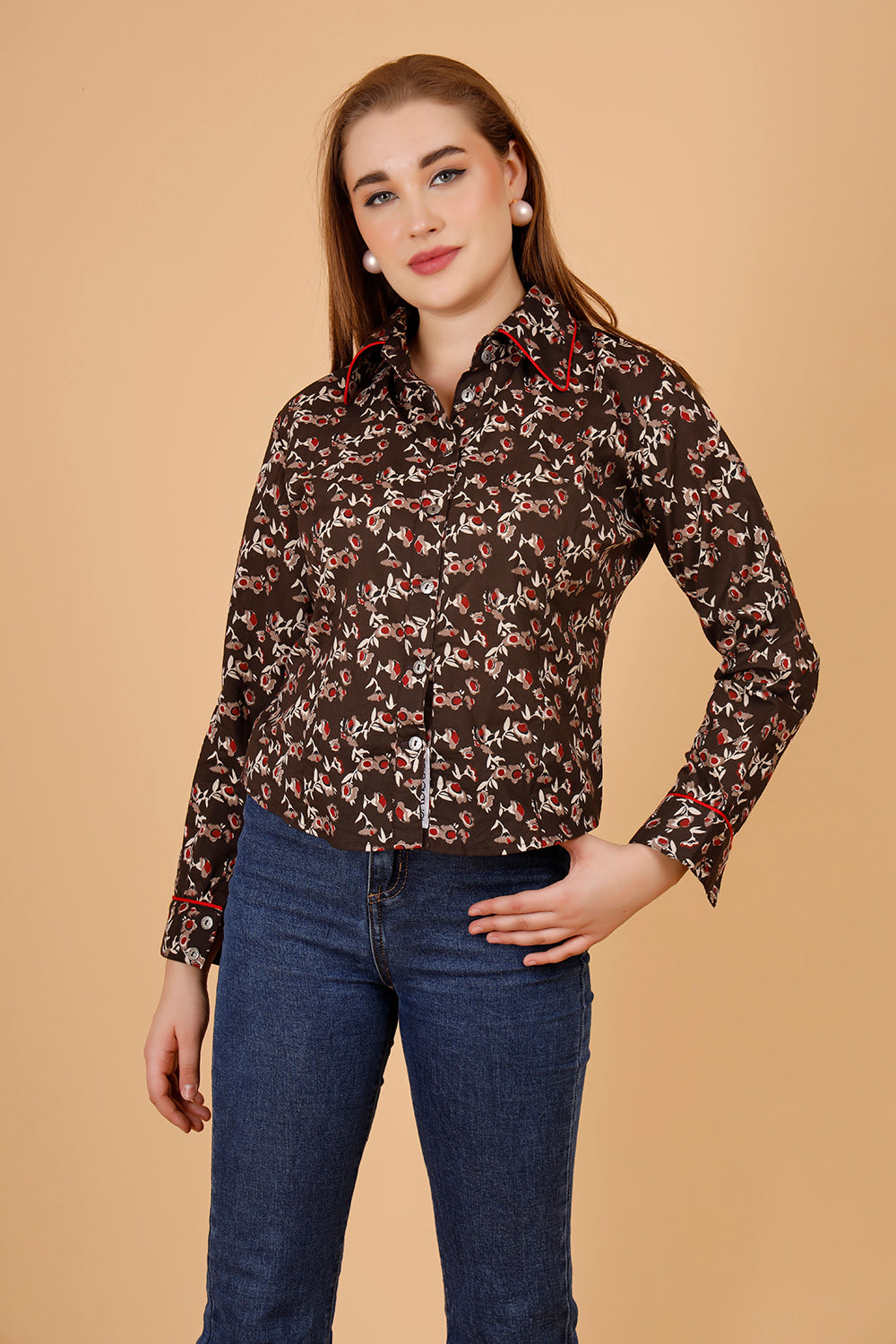 The model wears a comfortable womens blouse- a blockprinted cotton shirt, in colour brown, with red and beige jaipuri print, a structures short shirt for women, which is perfect for casual wear as well as office shirt