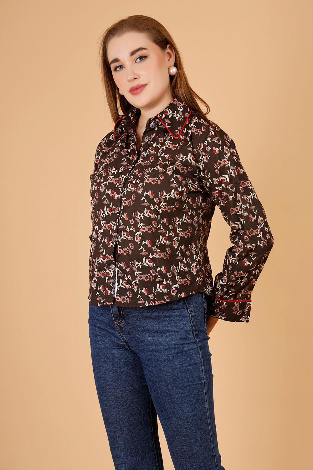 The model wears a comfortable womens blouse- a blockprinted cotton shirt, in colour brown, with red and beige jaipuri print, a structures short shirt for women, which is perfect for casual wear as well as office shirt